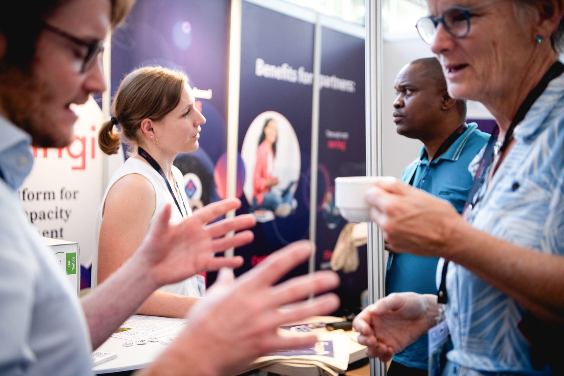 Four people in conversation at a conference booth.