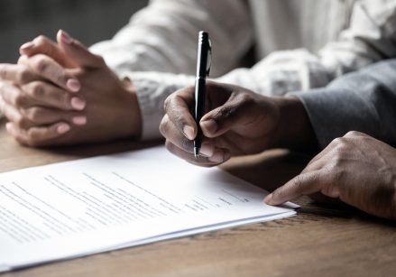 Two people signing documents.